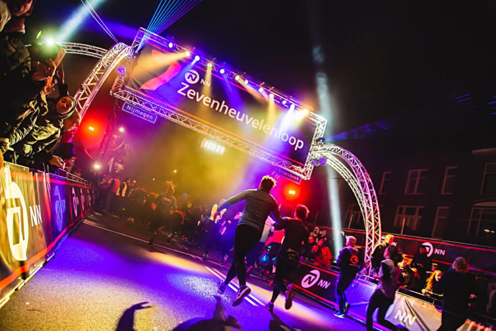 Startboog met verlichting en trussconstructie bij de Zevenheuvelenloop in Nijmegen, gerealiseerd door MAG Event Rental voor een veilige en sfeervolle loopervaring.