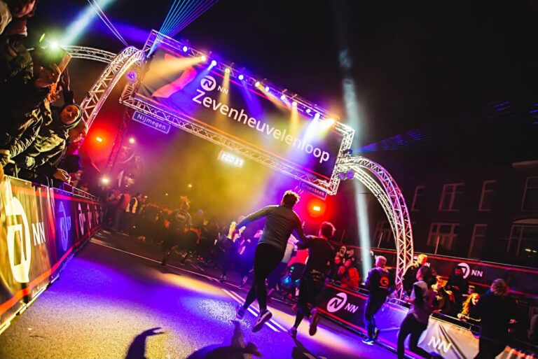 Startboog met verlichting en trussconstructie bij de Zevenheuvelenloop in Nijmegen, gerealiseerd door MAG Event Rental voor een veilige en sfeervolle loopervaring.